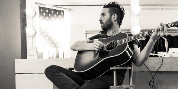 Mondo Cozmo holding guitar in studio dressing room