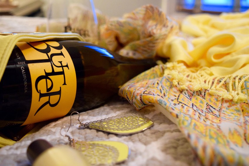 Bottle of JaM Cellars Butter lying on array of Spring clothing articles