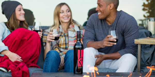 Three people sitting on couch enjoying JaM Cellars wine