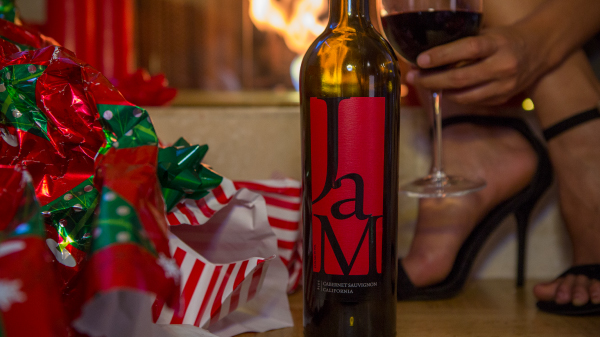 Red and green Christmas decorations with bottle of JaM Cellars wine with red label