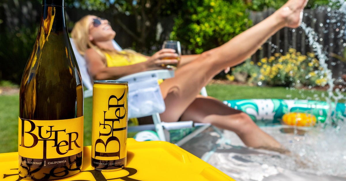 Lying in lawn chair with glass of JaM Cellars Butter with bottle in foreground