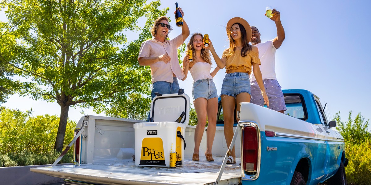 Group in back of pickup truck enjoying JaM Cellars ButterCan & Butter Chardonnay