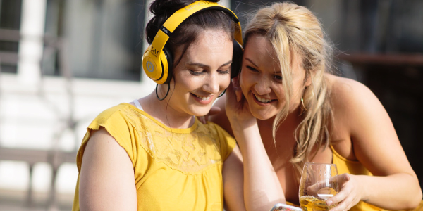 Two women with headphones listening JaMs playlist