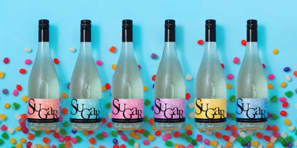 Six bottles of JaM Cellars Sugar against turquoise blue background with confetti