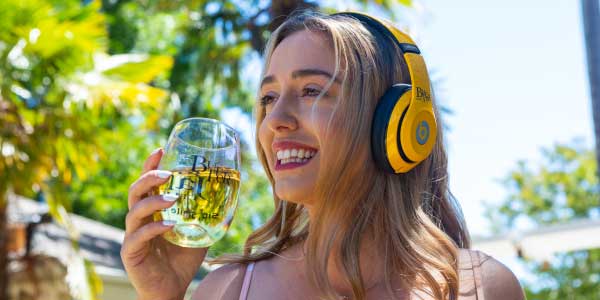 Woman with headphones sipping JaM Cellars Butter wine