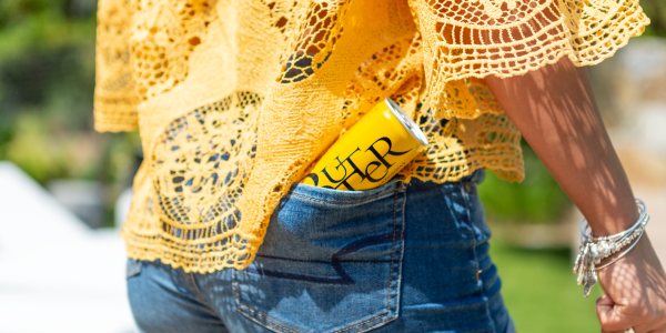 JaM Cellars ButterCan in back pocket of woman wearing lacy butter-yellow top