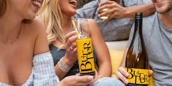 Two women and man enjoying JaM Cellars ButterCans and bottle of Butter wine